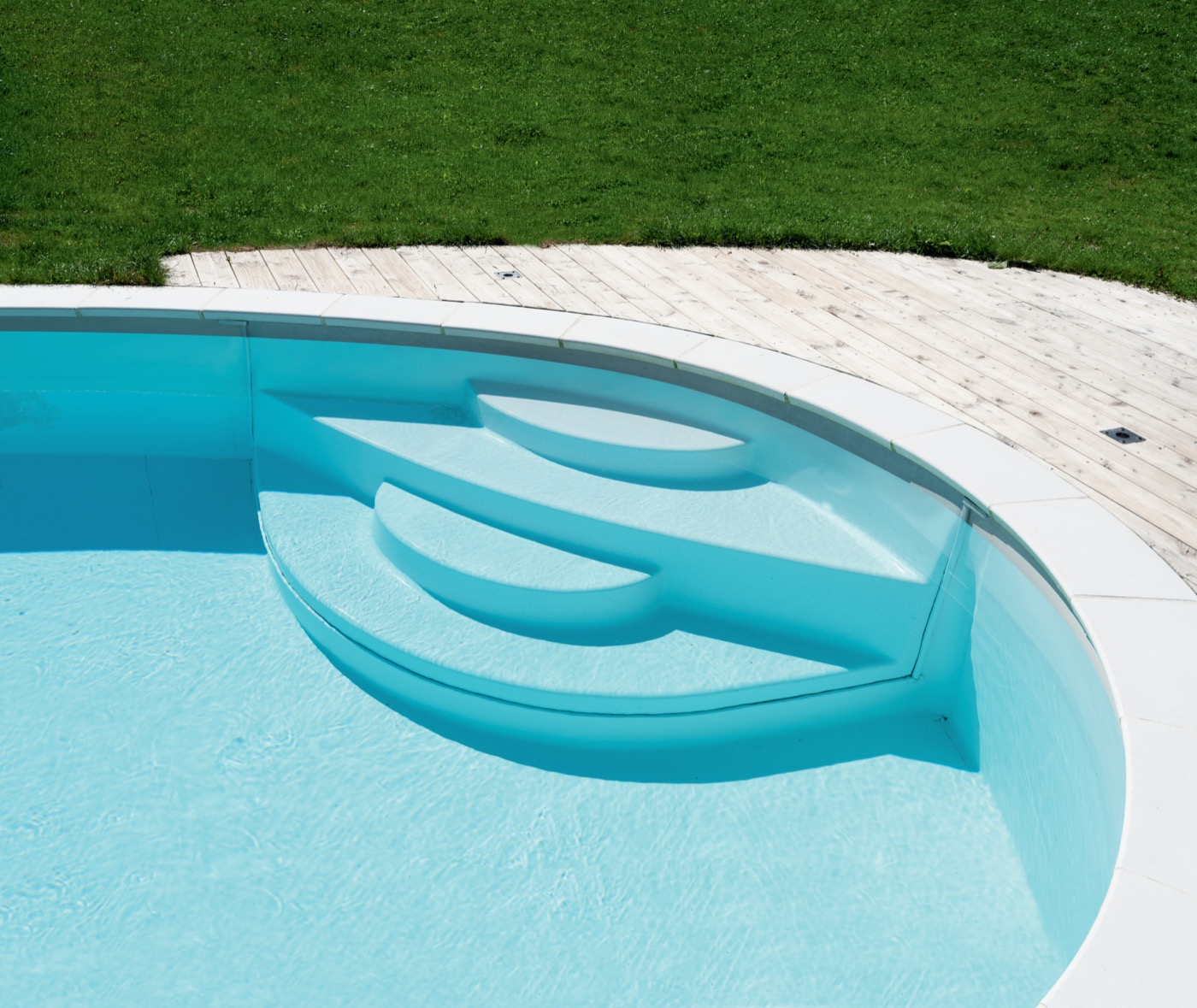 Detailaufnahme einer integrierten Pooltreppe im hellblauen Wasser