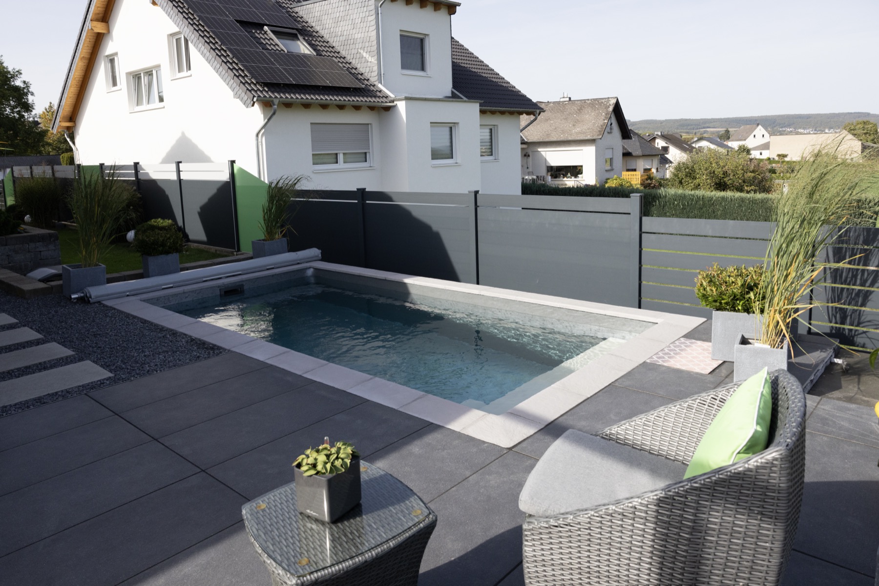 Moderner Gartenpool an Terrasse und Wohnhaus